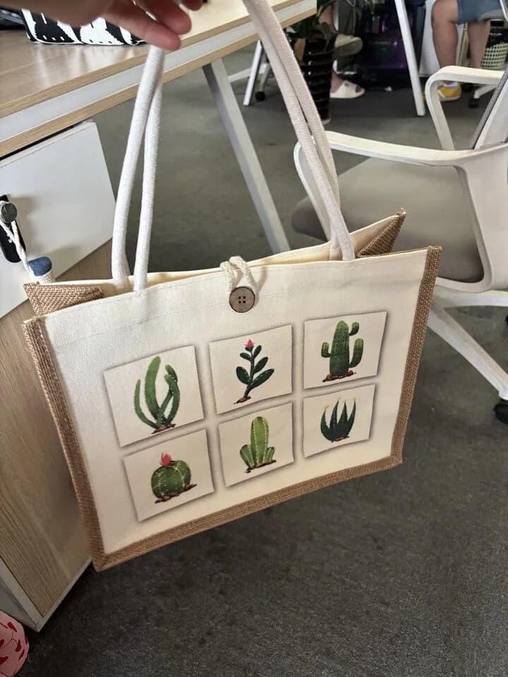 Tote bag with six cactus illustrations, contrasting side panels and a button closure