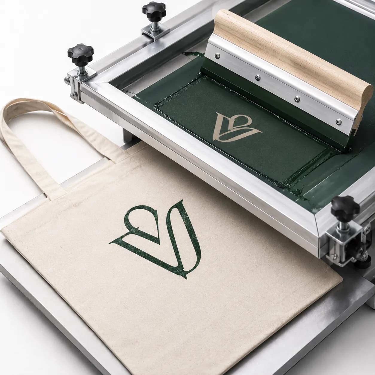 Screen-printing frame applying a single-colour logo to a natural tote bag