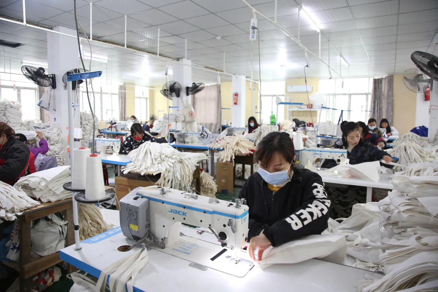 Sewing operators and fabric bags in a manufacturing partner workshop